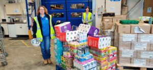 Food bank volunteers standing beside donated supplies in Swindon