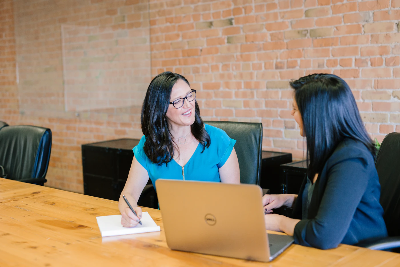 Two colleagues reviewing work together at a laptop