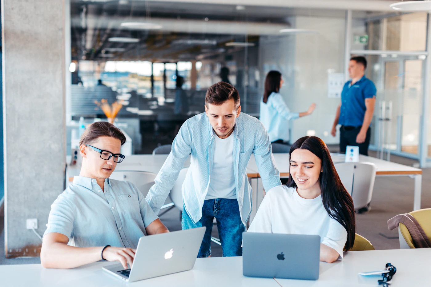 Office colleagues working together across two laptops