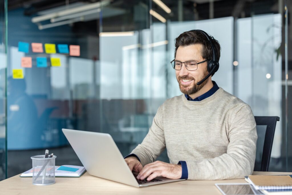 An IT technician prepares a laptop for a new starter, part of the setup costs in a startup technology budget.