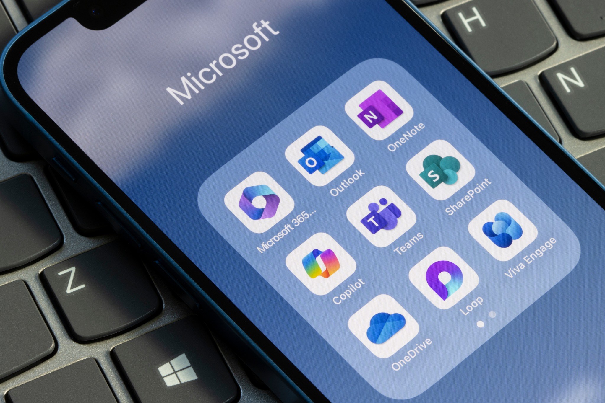 Two colleagues compare a Microsoft 365 storage report with an archive checklist and labelled project folders.